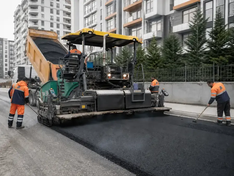 Finişer ile sıcak asfalt serimi yapan saha ekibi